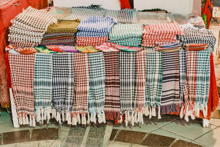 Traditional headdresses of the East, multicolored kufiyas as tourist souvenirs at night street market.の写真素材