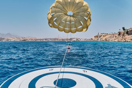 Senior white woman with gray hair is fearless and fun parasailing over Red sea.の写真素材