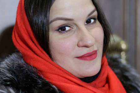 Close-up portrait of attractive Asian young woman wearing red headscarf, looking at camera.の写真素材
