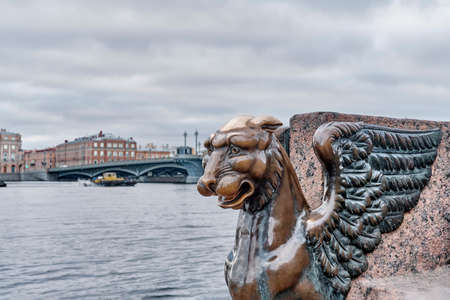 St.Petersburg, Russia. Sculpture of mythical griffin on embankment and bridge across Neva river.の写真素材