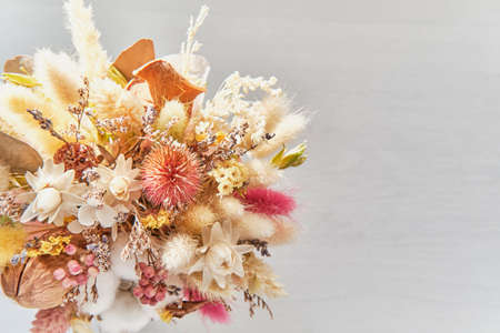 Beautiful delicate bouquet of dried flowers on a gray wooden blurred background.の写真素材