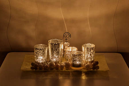 Christmas night composition on coffee table. Burning candles, golden glass candlesticksの写真素材