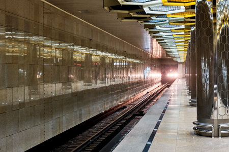 Glowing headlights of train leaving tunnel to underground metro station.のeditorial素材