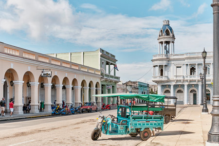 Historic center of city Cienfuegos, Cuba. Taxi motorcycles with passenger body. House of Cultureのeditorial素材