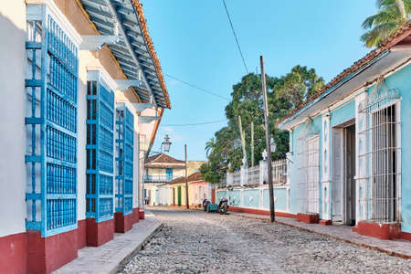 Cobblestone street with coloured buildings, wooden window bars in colonial old town Trinidad, Cubaの写真素材
