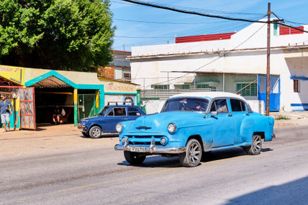 Old blue retro car driving along street in non-tourist area of Havana, Cuba.のeditorial素材
