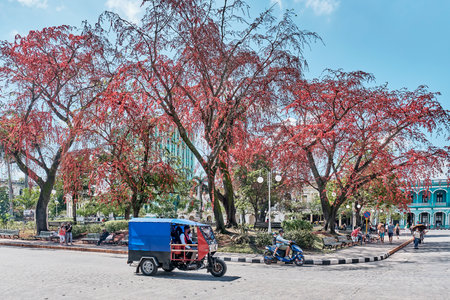 View of Vidal central park of Santa Clara, Cuba. Motorcycle taxi moving along road.