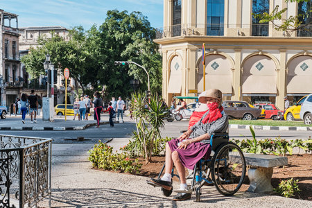 Senior woman in wheelchair resting in city park of Havana, Cuba.のeditorial素材