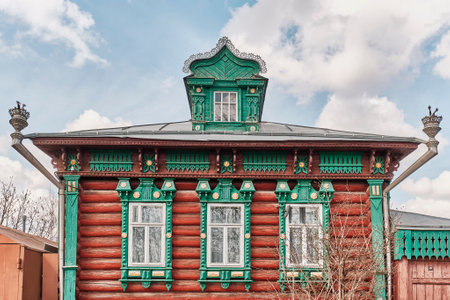 Facade of russian log house with dormer window on roof and carved wooden decorationsのeditorial素材