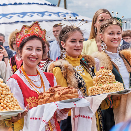 Bashkir and Russian girls in national festive clothes holding traditional pies at Sabantuy holidayのeditorial素材