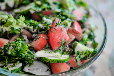 Salad of fresh vegetables and herbs, with vegetable oil. Close-up.の写真素材