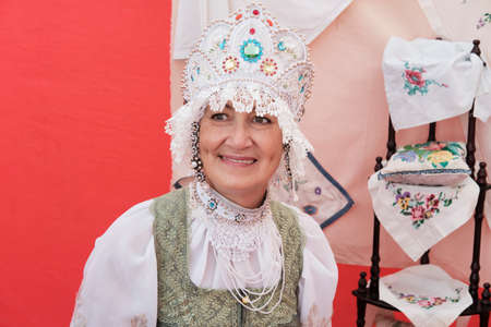 Portrait of smiling senior woman in stylized ancient Russian headdress - kokoshnik at rural holiday.の写真素材