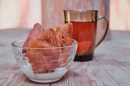 Buryat Mongolian dessert. Baking, boovy, with condensed milk in glass cup on wooden table.