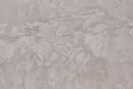 Blank plastered wall beige color with cracksの写真素材
