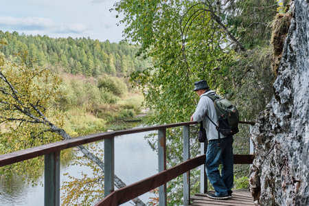 Senior male hiker, admiring landscape on wooden hiking trail near cliff. Nature park Deer streamsの写真素材