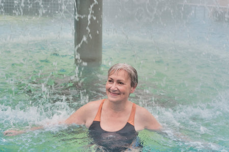 Mature woman in outdoor thermal pool.