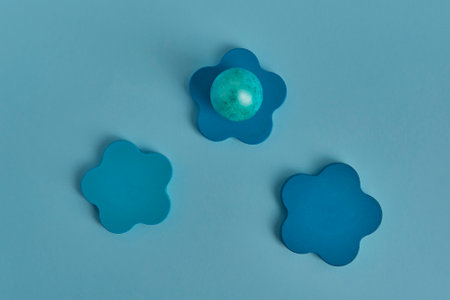 Painted aquamarine egg, wooden round podium. Flat layの写真素材