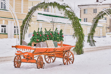 Street decoration. On wooden old cart Christmas trees with Christmas balls, boxes with gifts.の写真素材