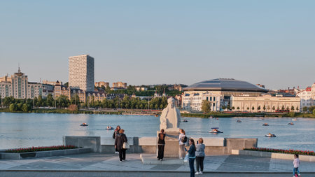 Kazan, Russia - June 5, 2023: Summer cityscape. Tourists near monument to Tatar educator Marjani on Nizhny Kaban Lake embankment. People riding catamarans.のeditorial素材
