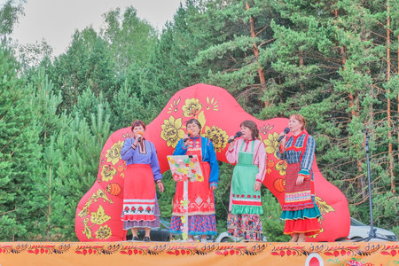 Four mature women in stylized traditional ethnic chuvash clothes singing on stage.のeditorial素材