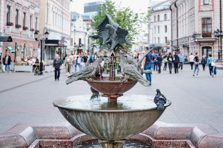 Kazan, Russia - June 7, 2023: Close-up of fountain with sculpture composition Pigeons on pedestrian tourist street Bauman. Sculptor IN Bashmakov, 2000. Pigeons drinking water from fountain bowls.のeditorial素材