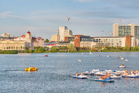 Kazan, Russia - June 17, 2023: People riding pedal boats on Nizhny Kaban lake in downtown. Active leisure. Summer cityscape.のeditorial素材