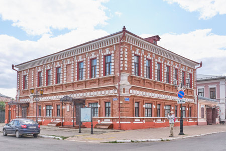 Yelabuga, Russia - June 18, 2023: Historic building, Stakheev's trading office, 1880s. Architectural monument, used as commercial building. Historical downtown. Male tourist takes pictures on his phoneのeditorial素材