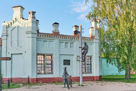 Yelabuga, Russia - June 18, 2023: Sculptural composition Signalman and postman. Bronze monument to workers in communications industry, 2007, sculptor Demchenko. Wall of former textile factoryのeditorial素材