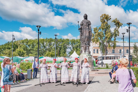 Irbit, Russia - August 11, 2023: Irbit Fair. Five mature women in concert dresses, vocal group, singing in front of the audience on Lenin Square. Restored monument to Catherine II by sculptor Mikeshin.のeditorial素材