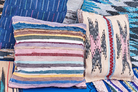 Small pillows with homespun colorful original pillowcases. Rustic traditional hand woven textile things made with fabric scrap, recycled material. Zero waste.の写真素材