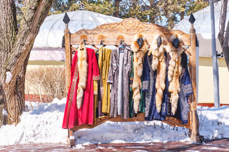 Carved wooden hanger with Kazakh festive colorful clothes for a tourist photo shoot. Traditional...