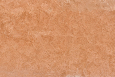 Texture of unevenly painted terracotta-colored plastered wall as abstract background.の写真素材
