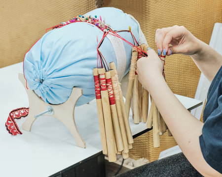 Female hands spin webbing on bobbinets. Special lace weaving technique, pattern created using...