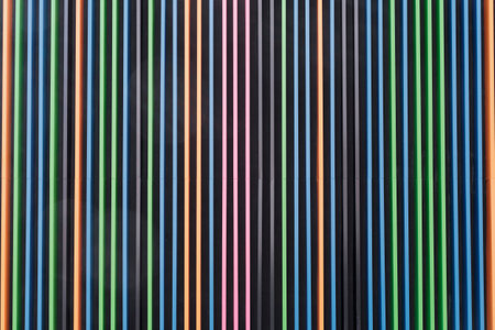 Symmetrical volume pattern of vertical colored stripes on dark background. Stripes alternate - blue,...