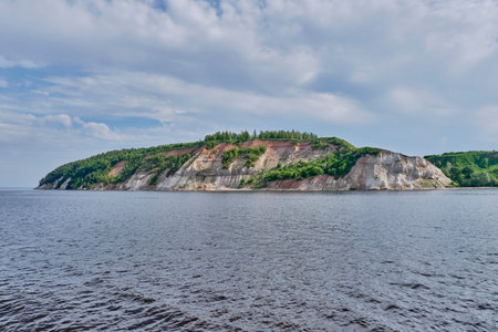 A striking Volga River landscape at Mount Lobach Nature Reserve, Kamskoe Ustye, Russia. Steep cliffs with lush greenery and layered rocks offer breathtaking views near the Volga-Kama confluence.の写真素材
