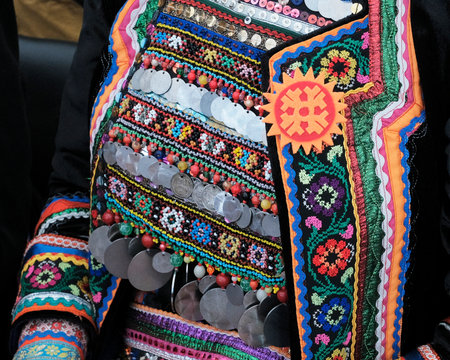 Close-up of Mari womens folk costume, richly decorated chest ornament and jacket with ribbons,...
