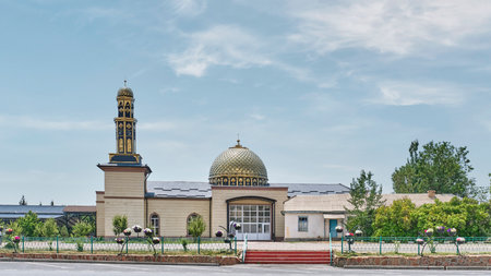 Contemporary mosque in resort town of Cholpon-Ata, located on shores of Lake Issyk-Kul. Golden patterned dome and tall, slender minaret. Islamic culture and modern architecture of Kyrgyzstan.の写真素材