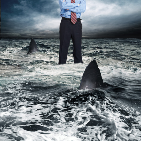 Businessman surrounded by sharkの写真素材