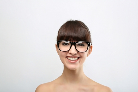 Funny expression. A beautiful woman with a funny expression wearing glasses on a pink background.の写真素材