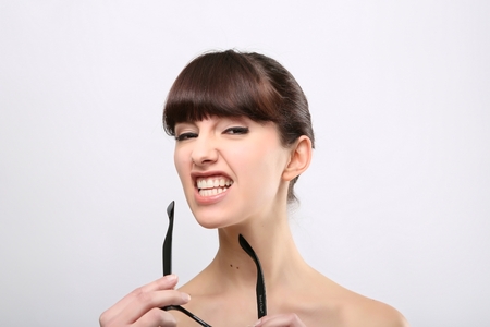 Funny expression. A beautiful woman with a funny expression wearing glasses on a pink background.の写真素材