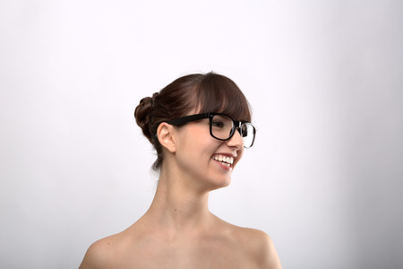 Funny expression. A beautiful woman with a funny expression wearing glasses on a pink background.の写真素材