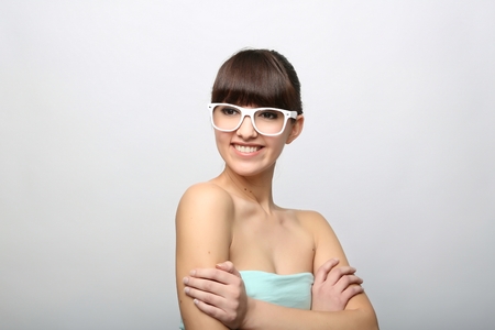Funny expression. A beautiful woman with a funny expression wearing glasses on a pink background.の写真素材