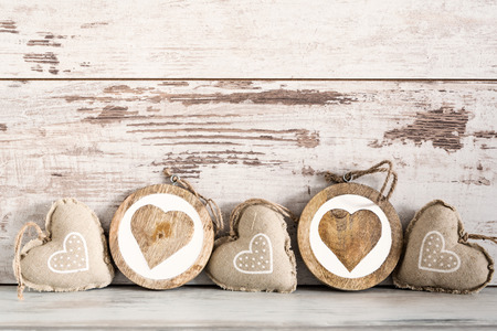 Valentines Day background with patterned textile hearts on old woodenの写真素材