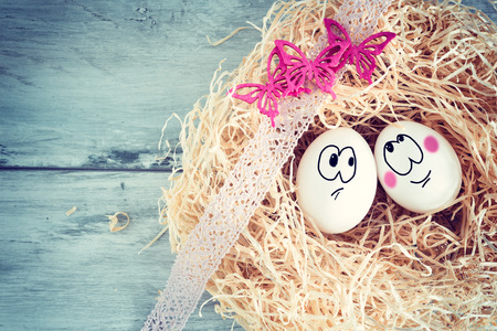 White egg with funny face in strawの写真素材