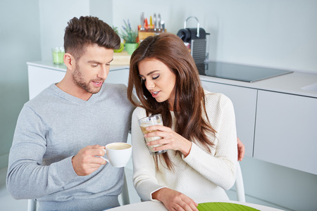 Happy Couple Enjoying Breakfast In Kitchen in an apartmentの写真素材