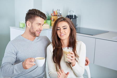 Happy Couple Enjoying Breakfast In Kitchen in an apartmentの写真素材