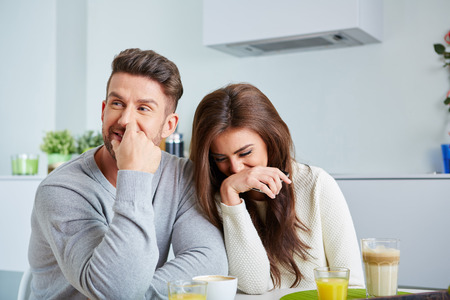 Smiling lovers in front of invoices in houseの写真素材