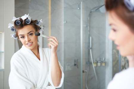 Woman applying make up with cosmetic brushの写真素材