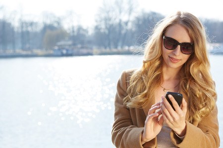 A portrait of a smiling beautiful woman talking on the phoneの写真素材