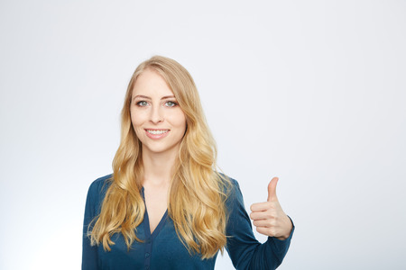 Young Woman Showing Thumb Up Sign On White Backgroundの写真素材